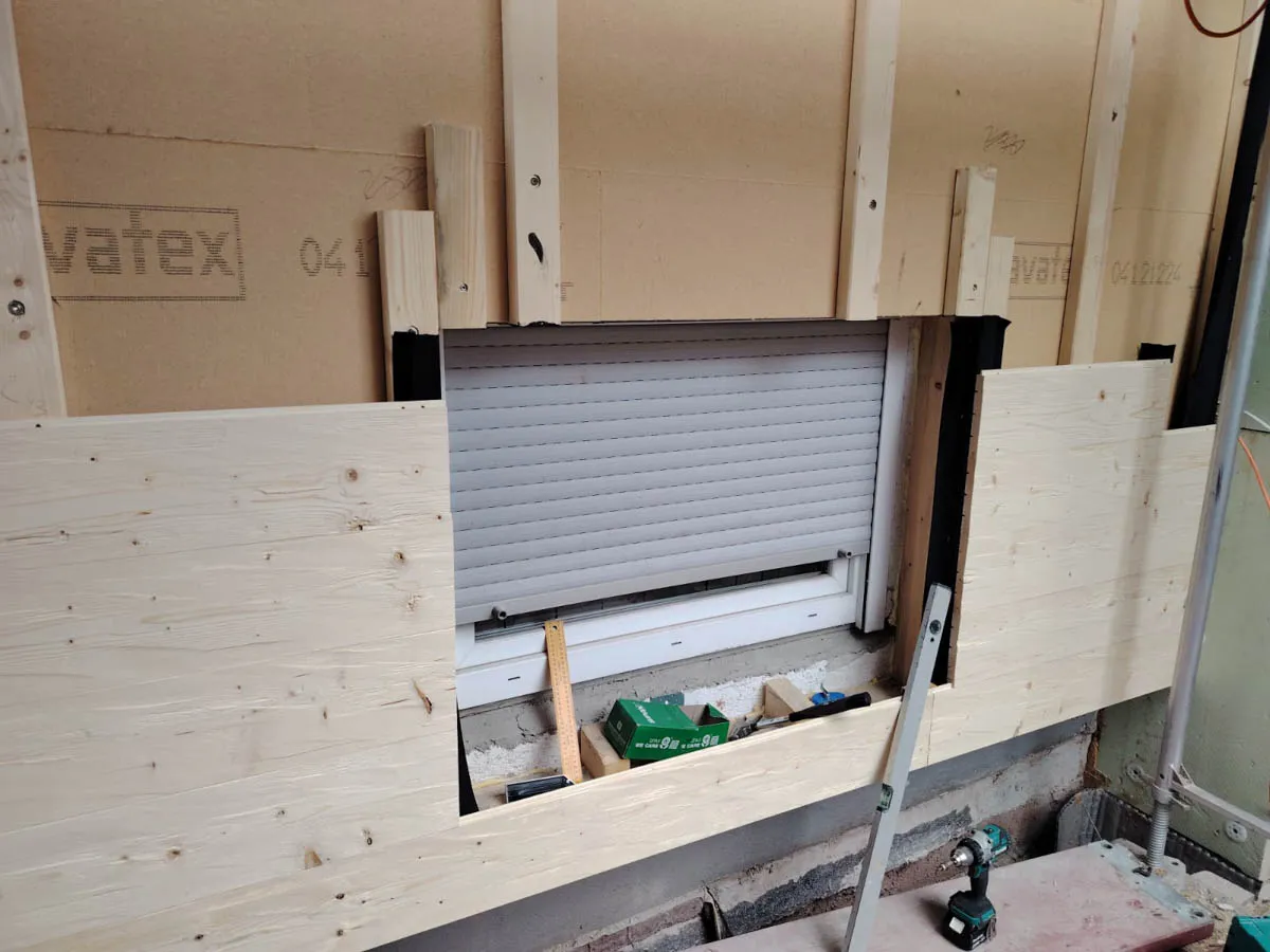 Montage einer hinterlüfteten Holzfassade mit sichtbarer Unterkonstruktion und Fensteröffnung