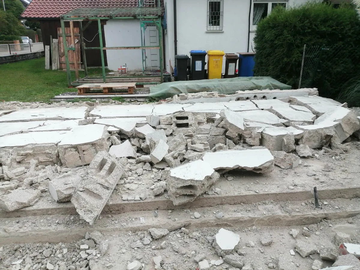 Abbrucharbeiten mit freigelegter Bodenplatte und Bauschutt auf dem Grundstück