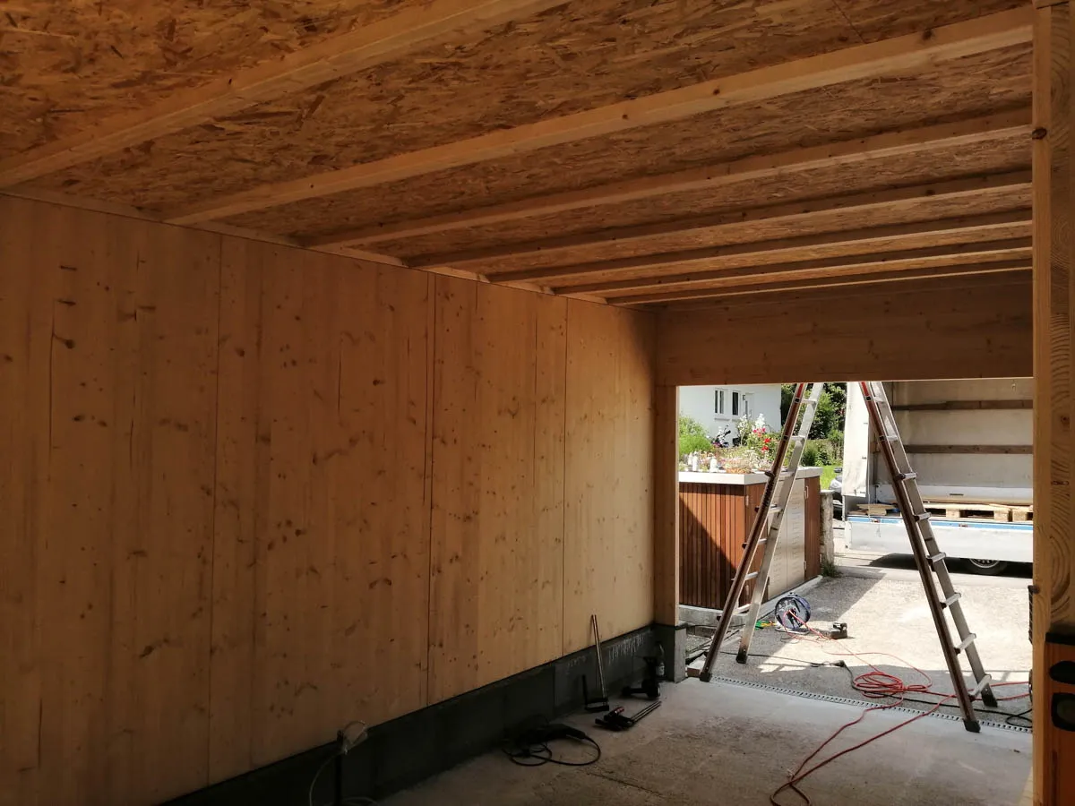 Innenansicht der Garage mit montierten Holzbauelementen und Deckenbalken