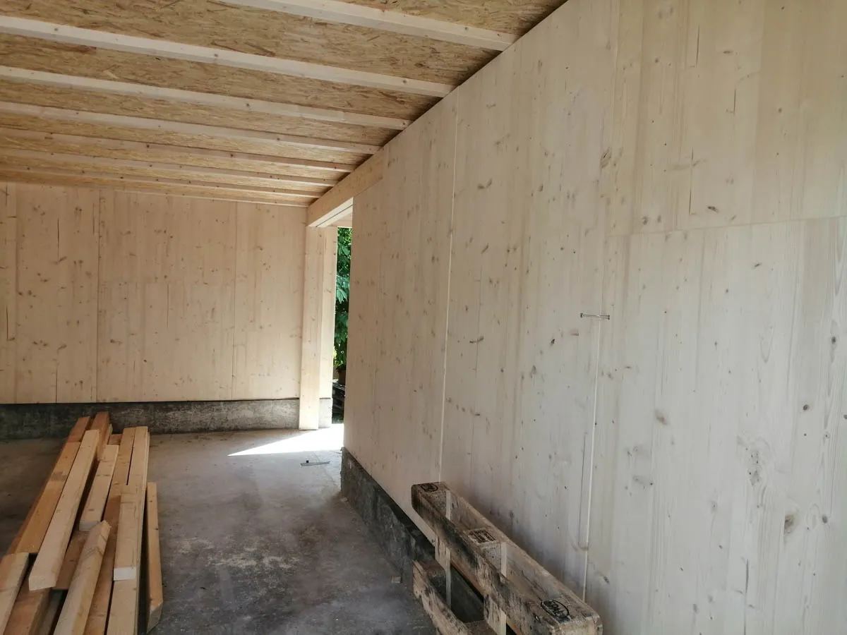 Innenraum der Garage mit sichtbarer Holzdecke und Wandverkleidung