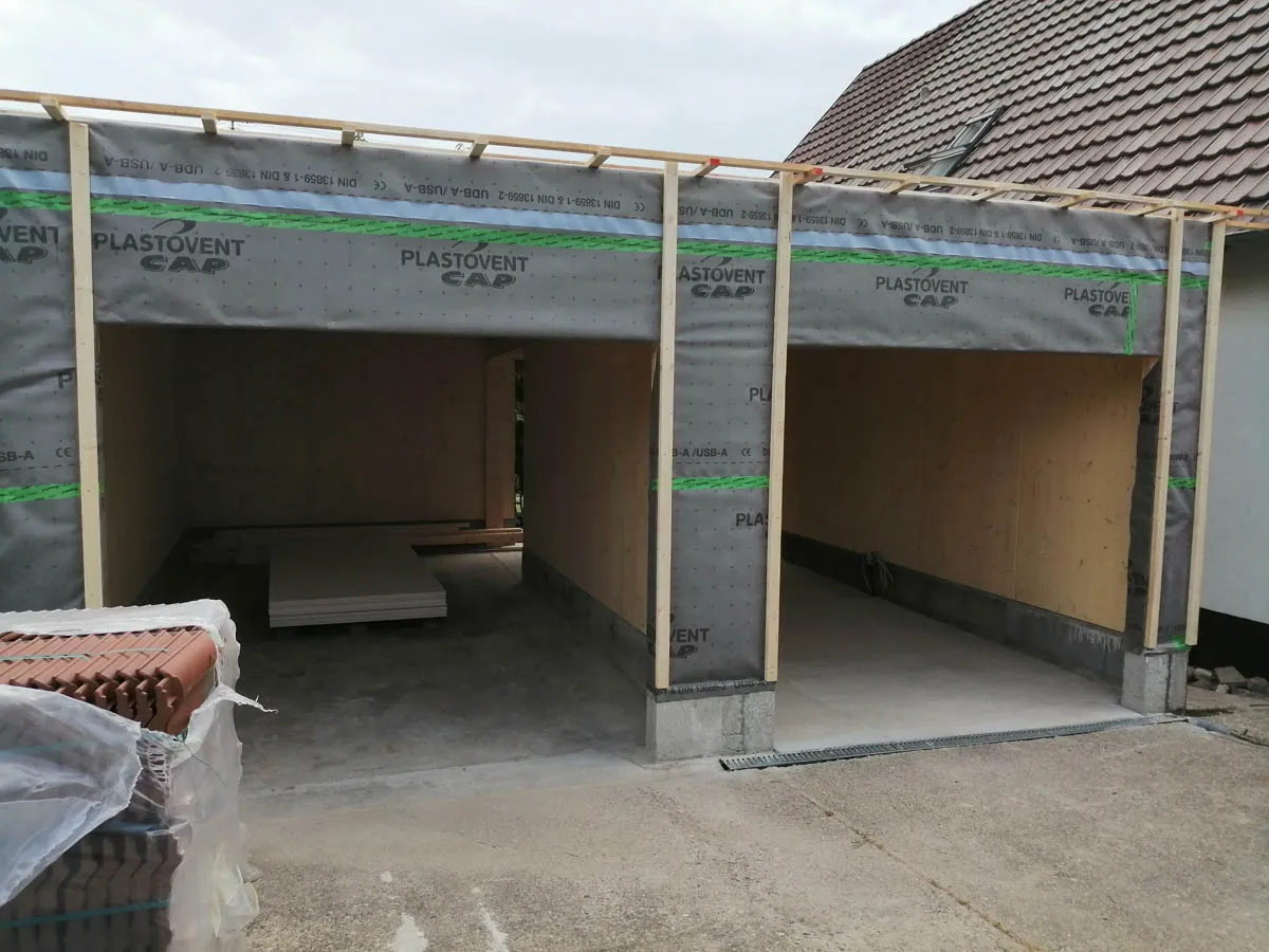 Außenansicht der Garage während des Neubaus mit offener Einfahrt