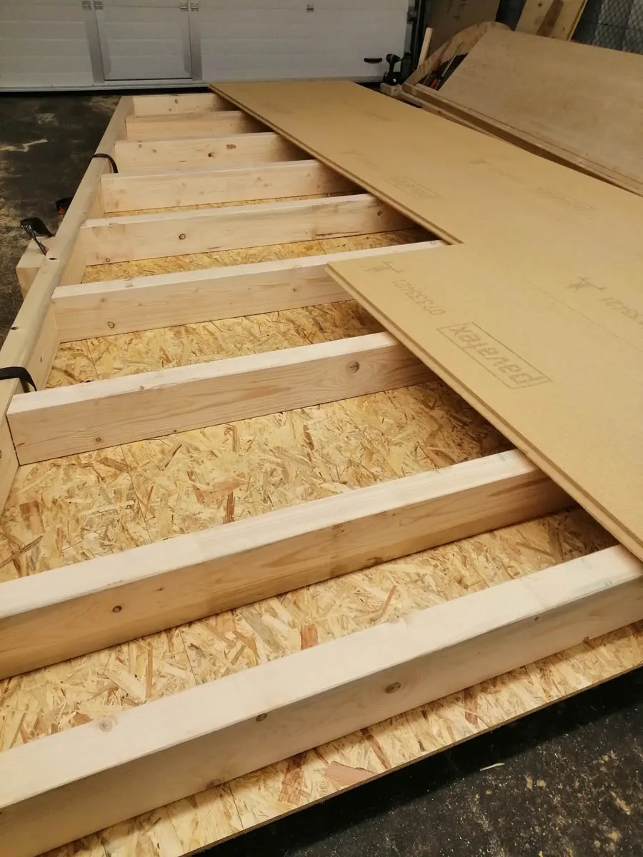 Vorgefertigtes Holzbodenelement mit Balkenlage und Holzwerkstoffplatten in der Werkhalle