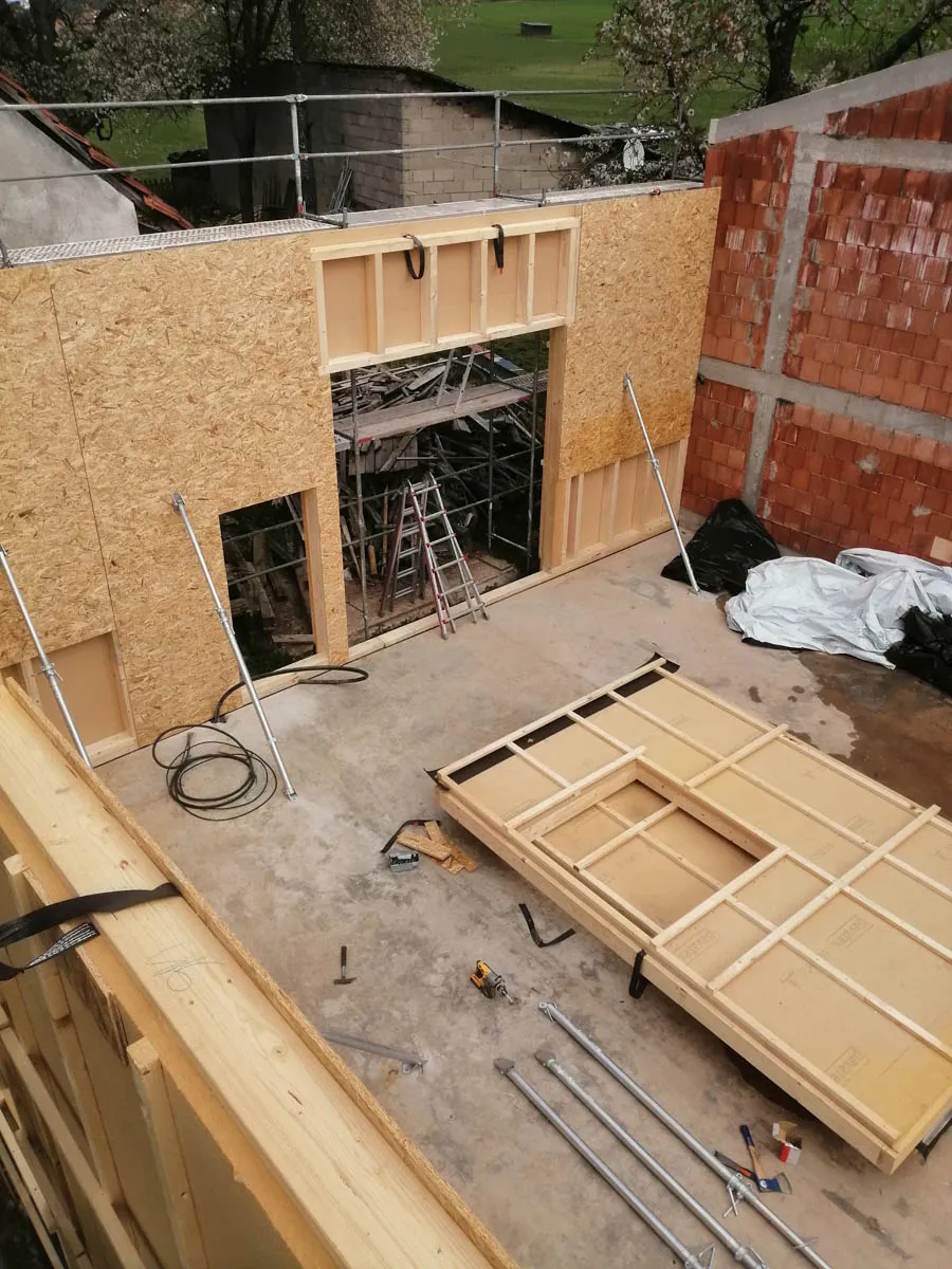 Montierte Holzwände mit Fenster- und Türöffnungen beim Neubau der Werkhalle