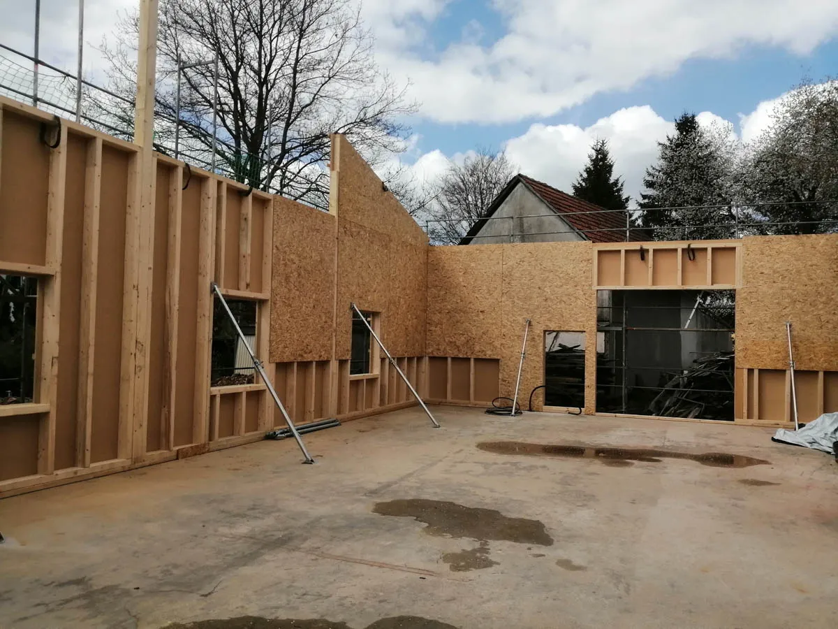 Innenansicht der Werkhalle mit aufgestellten Holzwänden und sichtbarer Holzrahmenkonstruktion